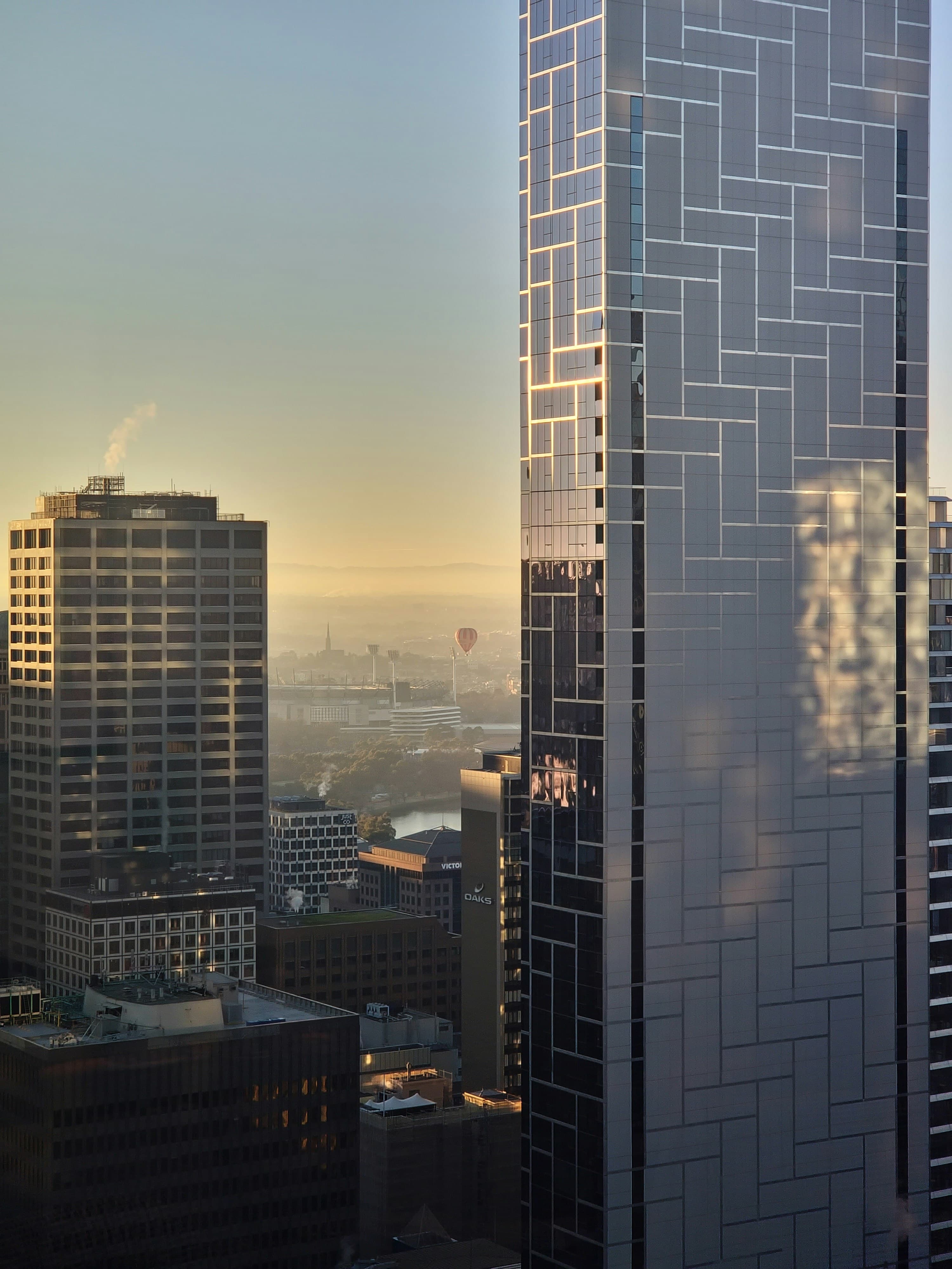 Modern glass tower at golden hour with city horizon